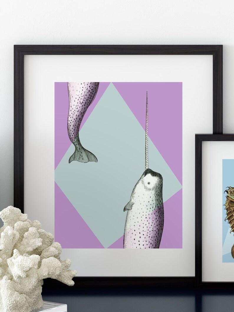 May include: Framed art print featuring a detailed illustration of a narwhal with a long tusk, set against a geometric background of lavender and light blue. The artwork is in a black frame, suitable for wall decor.