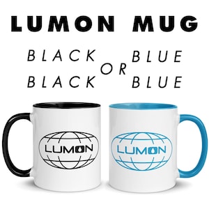 Puede incluir: Dos tazas de cerámica blancas con la palabra "LUMON" y un diseño de globo. Una taza tiene un asa y un interior negros, la otra tiene un asa y un interior azules. El texto superior dice "LUMON MUG" y "BLACK OR BLUE".