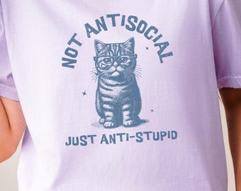 May include: A lavender t-shirt with a graphic of a cat wearing glasses and the text "Not Antisocial Just Anti-Stupid".
