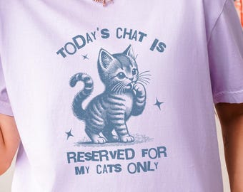 May include: A lavender t-shirt with a blue graphic of a cat and the text "Today's chat is reserved for my cats only."