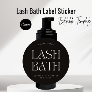 Può includere: Etichetta adesiva in bianco e nero per una bottiglia di detergente per il bagno delle ciglia. L'etichetta presenta il testo "LASH BATH" con una grafica di ciglia stilizzata. Il testo "BUSINESS NAME" appare sopra il testo principale. L'etichetta include anche il testo "LUXURY LASH CLEANSER 1 OZ | 30ML".