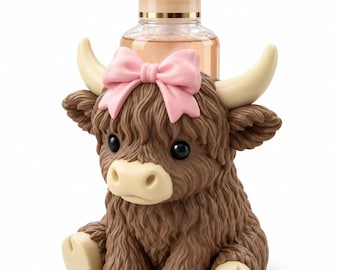 May include: A clear plastic soap dispenser with a pump top, encased in a brown, textured highland cow figurine. The cow has cream-colored horns and hooves, black eyes, and a prominent light pink bow positioned between its ears.