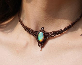 May include: A brown macrame choker necklace with a large iridescent oval gemstone pendant.