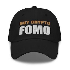 Puede incluir: Gorra de béisbol negra con texto bordado en blanco que dice "BUY CRYPTO FOMO" en letras doradas.
