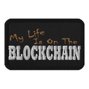 May include: Black embroidered patch with white text that reads "My Life Is On The BLOCKCHAIN". The words "My Life" are written in brown cursive.