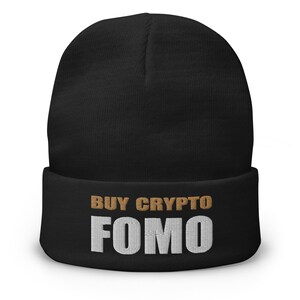 Puede incluir: Gorro negro con el texto "BUY CRYPTO FOMO" bordado en blanco y dorado.