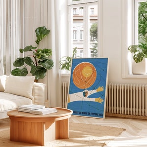 May include: A vintage poster with a blue background featuring a stylised illustration of a football player kicking a ball. The text on the poster reads "Championnat du Monde de Football 1954".
