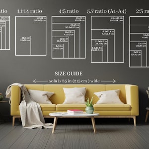K&ouml;nnte beinhalten: Ein Gr&ouml;&szlig;enleitfaden f&uuml;r Kunstwerke, der verschiedene Seitenverh&auml;ltnisse und die entsprechenden Abmessungen in Zoll und Zentimetern zeigt. Der Leitfaden ist an einer grauen Wand mit einem gelben Sofa und einem Couchtisch davor angebracht. Der Text "Sofa ist 85 Zoll (215 cm) breit" steht unter dem Leitfaden.