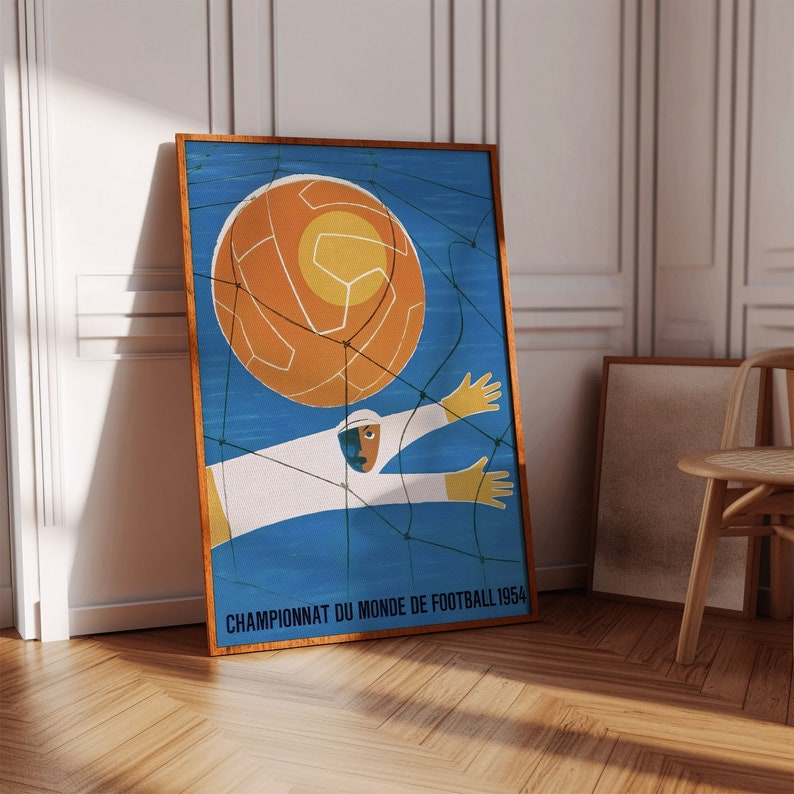 May include: A vintage poster with a blue background and a white figure catching a football. The ball is orange and white and the text reads "Championnat du Monde de Football 1954".