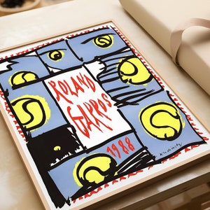May include: A framed poster with a colorful abstract design featuring tennis rackets and the words "Roland Garros 1988".