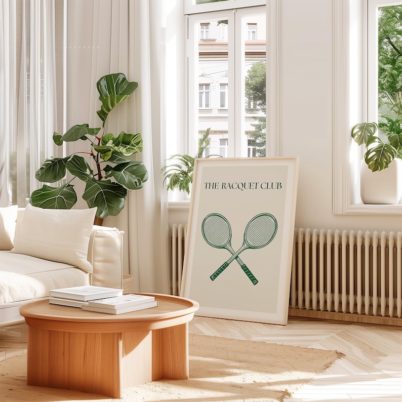 Puede incluir: Una impresi&oacute;n enmarcada con un fondo verde claro que presenta dos raquetas de tenis cruzadas y el texto "THE RACQUET CLUB".
