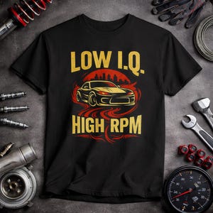 May include: Black t-shirt with a yellow sports car graphic, the text "LOW I.Q." above the car, and "HIGH RPM" below. The design includes a red skyline and wavy lines.