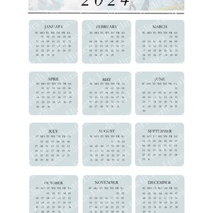 May include: A blue and white calendar for the year 2024. Each month is displayed in a separate square with the days of the week labeled. The calendar is decorated with a mountain scene and a person hiking.