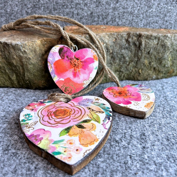 Trio of wood hearts with floral decoupaged design and foil accents, decoupaged image on wood hearts, natural on back, tied by twine.