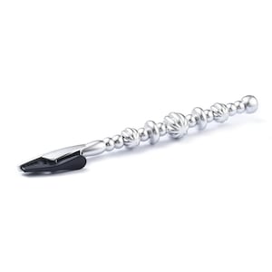 May include: A silver metal jewelry tool with a black tip. The tool has a series of decorative beads and textured elements along its length. The beads vary in size and shape, adding visual interest. The tool is designed for jewelry making.
