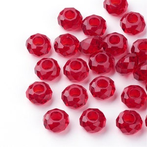 May include: A group of red crystal beads with a faceted design. The beads have a hole in the center for stringing.