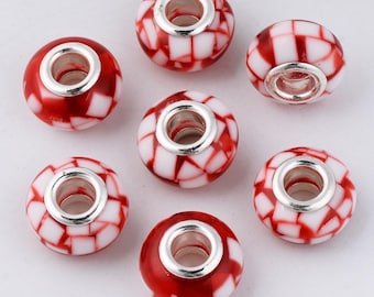 May include: Seven red and white glass beads with a checkerboard pattern. Each bead has a silver-colored metal core. The beads are round and have a hole through the center for stringing.