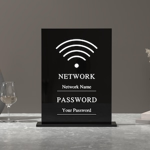Op de afbeelding: Zwart acryl bord met een wit wifi-symbool, de woorden "NETWORK", "Network Name", "PASSWORD" en "Your Password".