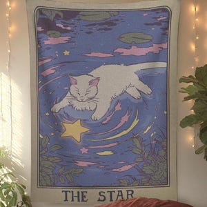 K&ouml;nnte beinhalten: Ein rechteckiges Wandbehang mit einer wei&szlig;en Katze, die in einem blauen Pool mit einem gelben Stern schwimmt. Das Design enth&auml;lt rosa und gelbe Details, mit dem Text "THE STAR" unten. Zum Aufh&auml;ngen an der Wand.