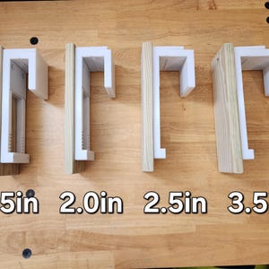 May include: Four white shelf brackets with different lengths: 1.5 in, 2.0 in, 2.5 in, and 3.5 in. The brackets are mounted on a wooden surface.