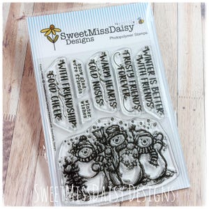 May include: A clear photopolymer stamp set by SweetMissDaisy Designs featuring three snowmen and various winter-themed sentiments including With Friendship and Good Cheers, Snow Glad We're Friends, Warm Hearts and Cold Noses, Frosty Friends Forever, and Winter Is Better With Friends.