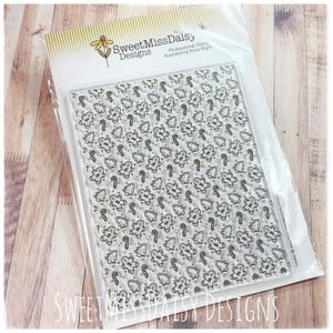 May include: A clear photopolymer stamp sheet by SweetMissDaisy Designs featuring a repeating pattern of gingerbread people, Christmas trees, and candy canes. The packaging includes the brand name and illustrator credit on a white header card.