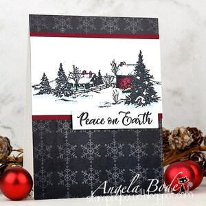 May include: A handmade Christmas card featuring a winter scene with a red barn and snow-covered trees. The card has a dark gray snowflake pattern and the words "Peace on Earth". Red ornaments are in the foreground.