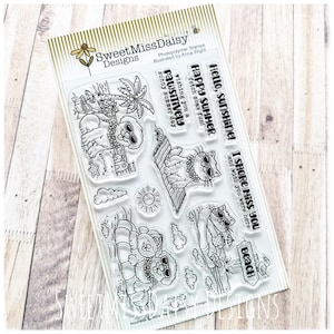 May include: A clear photopolymer stamp set by SweetMissDaisy Designs featuring summer-themed illustrations of cats and dogs wearing sunglasses, beach accessories, and phrases including Hello sunshine, Happy summer, and I shore miss you.