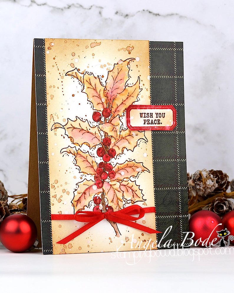 May include: A handmade Christmas card featuring a holly branch with red berries and leaves. The card has a plaid pattern on the right side and a red ribbon. The text "WISH YOU PEACE" is on a red label.