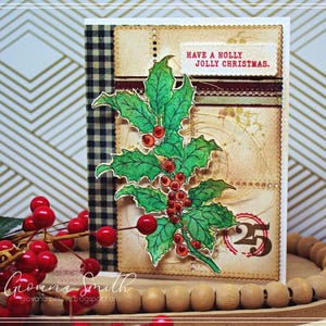 May include: A handmade Christmas card featuring a holly sprig with red berries. The card has a vintage aesthetic with a beige background, a gingham pattern, and the text "Have a Holly Jolly Christmas."