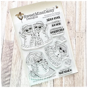 May include: A clear photopolymer stamp set by SweetMissDaisy Designs featuring illustrations of snowmen in summer settings. Includes snowmen with sunglasses, a sandcastle, a beach umbrella, a floatie, a starfish, a bird, and text phrases.