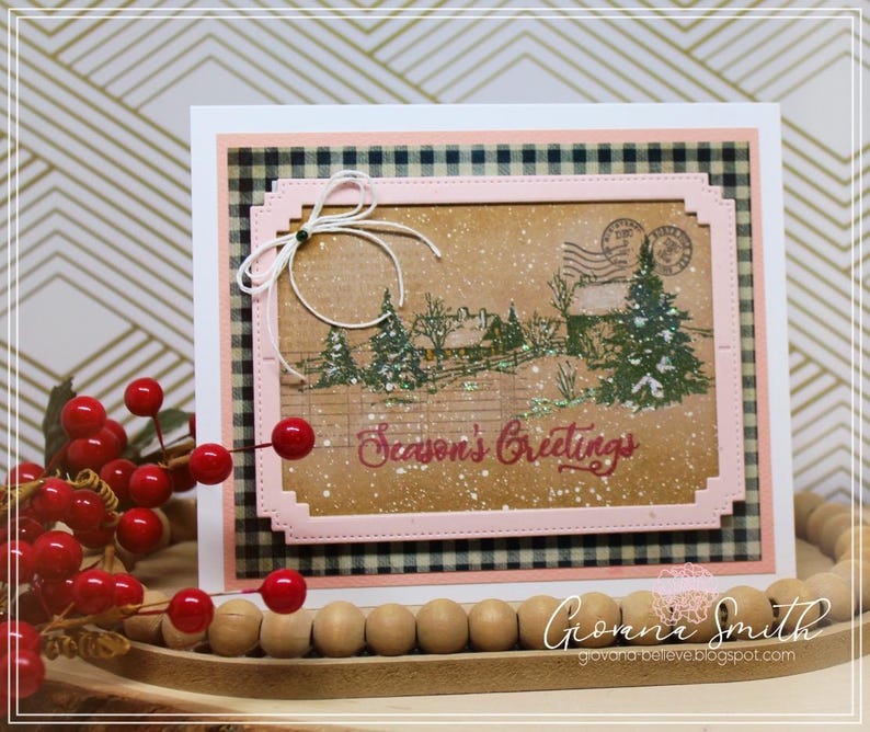 May include: A handmade Christmas card with a winter scene featuring trees, a house, and the text "Season's Greetings." The card has a pink border, a black and white checkered background, and a white bow.