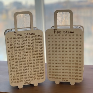 以下が含まれることがあります： 「FOR DREAM」と書いてある木製の旅行鞄の形をした箱が2つあります。箱には数字が印刷されており、それぞれの箱の下部に合計金額が記載されています。左側の箱の合計は5920、右側の箱の合計は11400です。