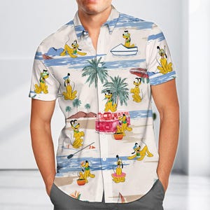 Może przedstawiać: Koszula z krótkim rękawem z powtarzającym się wzorem Pluto na plaży. Wzór obejmuje palmy, czerwonego vana i łódź, z Pluto w różnych pozach. Koszula ma jasne tło z niebieskimi i beżowymi poziomymi paskami.