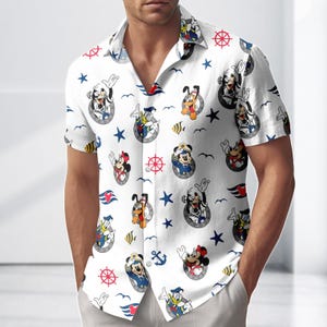 May include: White button-down shirt with a nautical theme. The shirt features cartoon characters in navy blue portholes, along with red and blue nautical symbols. The short-sleeved shirt has a classic collar and is made of a lightweight fabric.