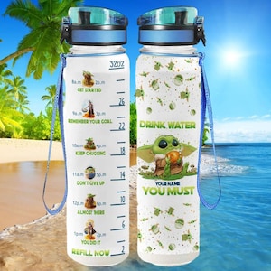 Può includere: Due bottiglie d'acqua da 32 once con sfondo bianco e un design del personaggio Baby Yoda verde. La bottiglia a sinistra ha un grafico di consumo di acqua basato sul tempo con il testo "Drink Water You Must".