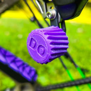 May include: A close-up of a purple 3D printed bike accessory with a logo that says "BO".