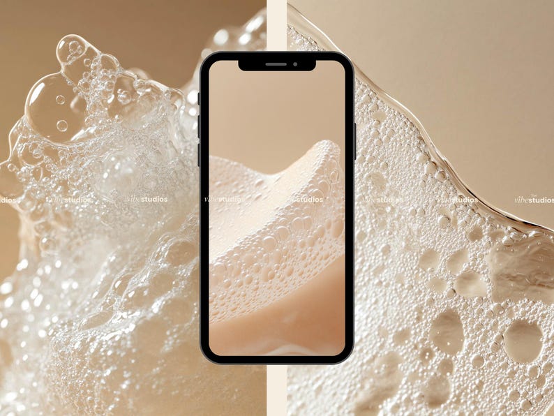May include: A close-up of a smartphone displaying a beige background with white bubbles. The phone is surrounded by a white foamy substance.