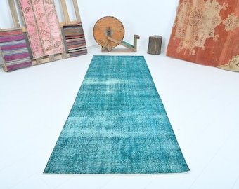 May include: A teal blue vintage rug with a faded, distressed look. The rug has a rectangular shape and is made of a soft, woven material.