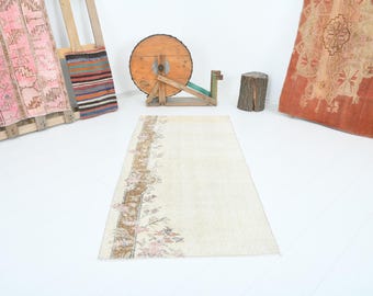 May include: A vintage off-white runner rug with a floral pattern along the edge. The rug has a faded, distressed look and is made of natural fibers.