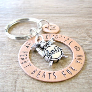 May include: Copper keychain with a drum charm and the text "My heart beats for you 12.20.17".