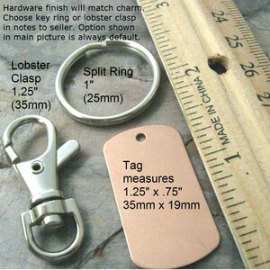 May include: A close-up of a silver lobster clasp and a silver split ring, both measuring 1.25 inches (35 mm) and 1 inch (25 mm) respectively. A copper-colored tag with the text "Tag measures 1.25" x .75" 35mm x 19mm" is shown next to a ruler.