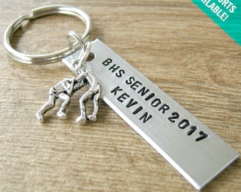 May include: Silver keychain with a wrestling figure charm and a rectangular tag that reads "BHS Senior 2017 Kevin".