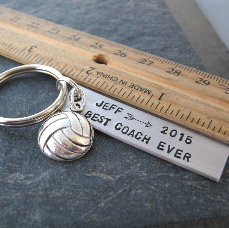 May include: Silver keychain with a volleyball charm and a metal tag that reads "Jeff Best Coach Ever 2015".