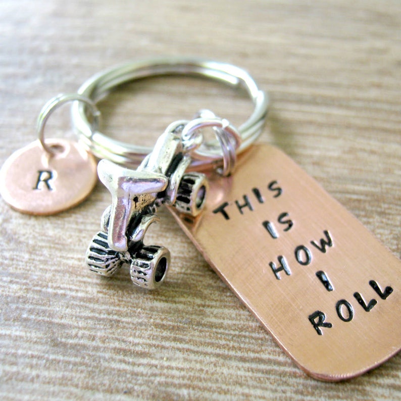 May include: A copper keychain with a silver go-kart charm and a tag that reads "This is how I roll".