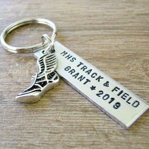 May include: Silver keychain with a running shoe charm and a silver tag that reads "MHS Track & Field Grant * 2019"