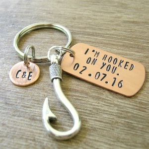 May include: A silver key chain with a hook charm and a copper tag that reads "I'm hooked on you. 02.07.16" and a smaller copper tag with the initials "C&E".