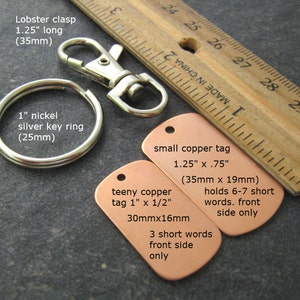 May include: Two copper tags with text on them. The larger tag is 1.25 inches by .75 inches and says "small copper tag 1.25" x .75" (35mm x 19mm) holds 6-7 short words. front side only". The smaller tag is 1 inch by 1/2 inch and says "teeny copper tag 1" x 1/2" 30mmx16mm 3 short words front side only".