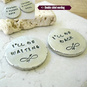 May include: Two silver metal discs with the text "I'll be waiting" on one side and "I'll be back" on the other side. Each disc has a small arrow and infinity symbol.