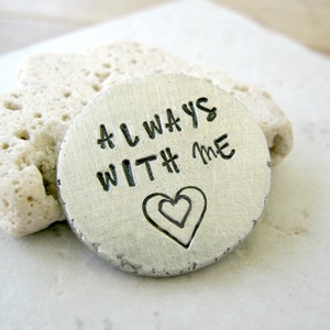 May include: A silver metal disc with the words "ALWAYS WITH # ME" engraved on it. A double heart design is engraved below the text.